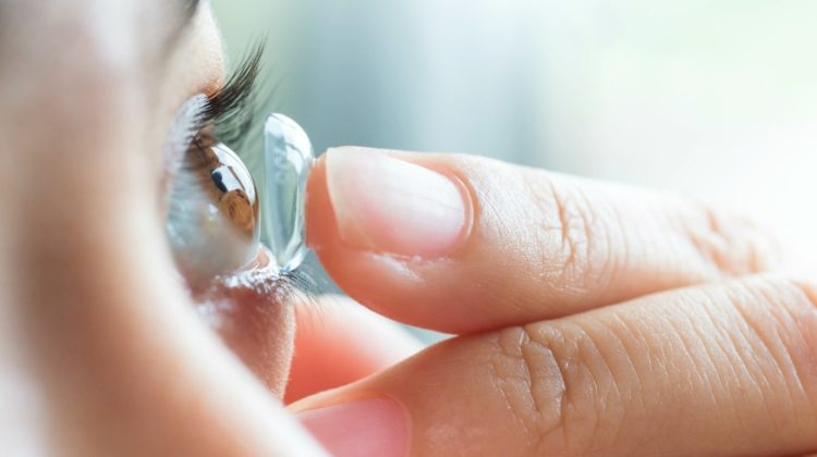 Feature | Young woman putting contact lens in her right eye, close up | Contact Lenses That Do The Thinking For You