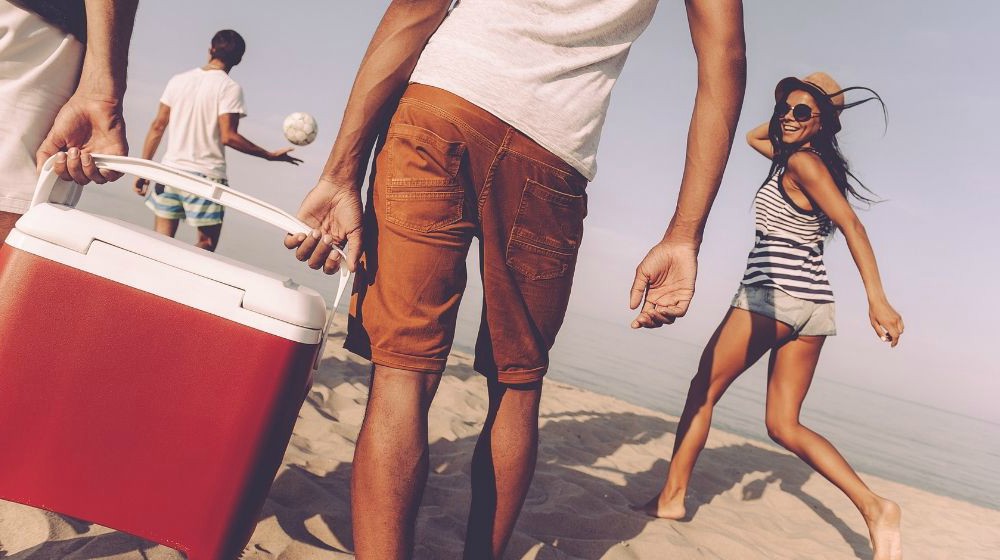 Featured | Friends carrying cooler on beach | Make Your Own YETI Cooler